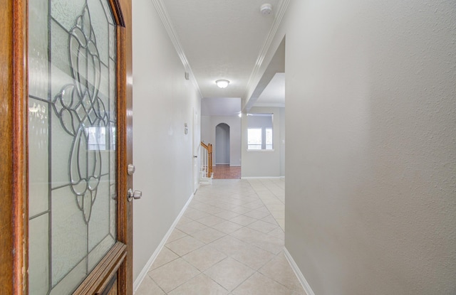 hall with ornamental molding and light tile patterned flooring