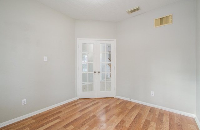 empty room with light hardwood / wood-style flooring and french doors