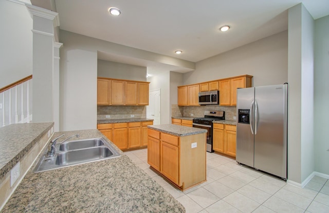 kitchen with light brown cabinets, sink, decorative backsplash, light tile patterned floors, and appliances with stainless steel finishes