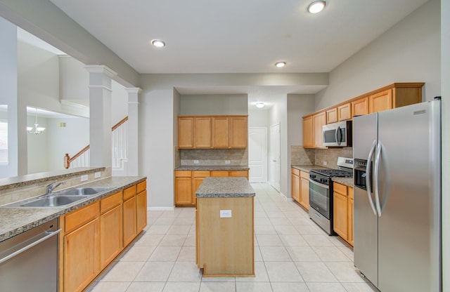 kitchen with tasteful backsplash, sink, a kitchen island, and appliances with stainless steel finishes