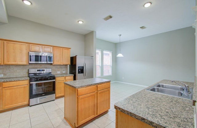 kitchen with decorative backsplash, stainless steel appliances, sink, pendant lighting, and a center island