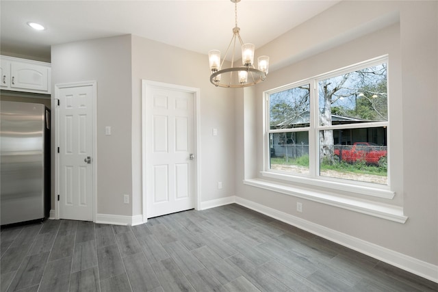 unfurnished dining area featuring a wealth of natural light and an inviting chandelier