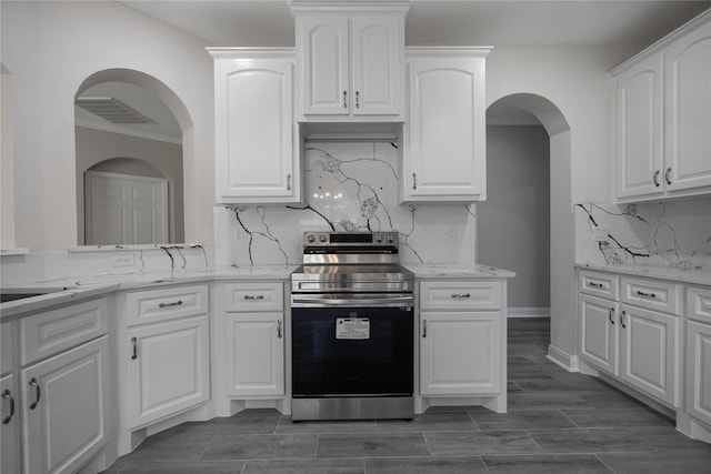 kitchen featuring white cabinets, tasteful backsplash, and stainless steel electric stove