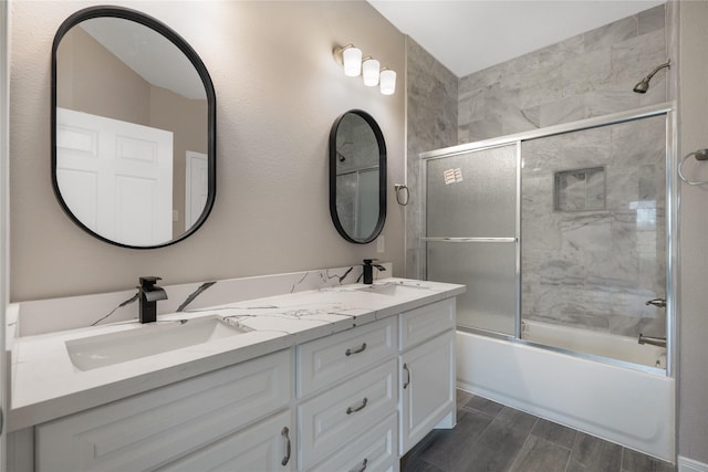 bathroom featuring shower / bath combination with glass door and vanity