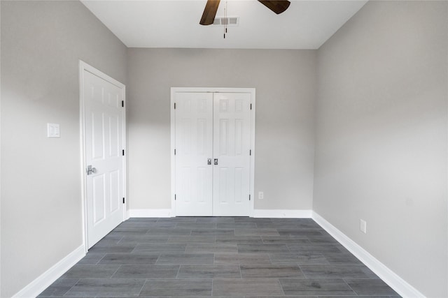 unfurnished bedroom with ceiling fan and a closet