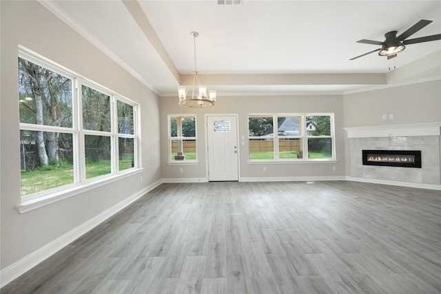 unfurnished living room with a high end fireplace, hardwood / wood-style floors, and ceiling fan with notable chandelier