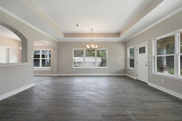 unfurnished dining area featuring a notable chandelier, dark hardwood / wood-style flooring, and a tray ceiling