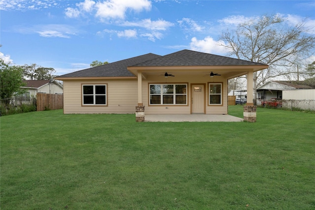 rear view of property featuring a yard, ceiling fan, and a patio area