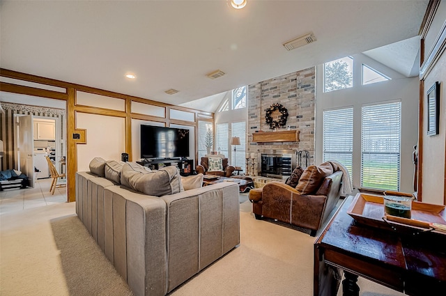 living room featuring a fireplace, light carpet, vaulted ceiling, and a healthy amount of sunlight