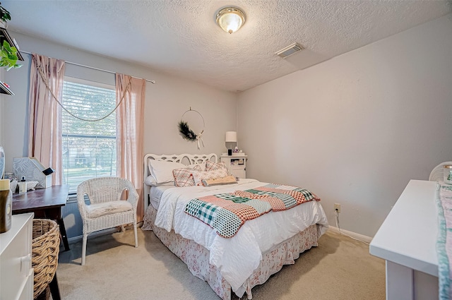 bedroom featuring a textured ceiling and light colored carpet