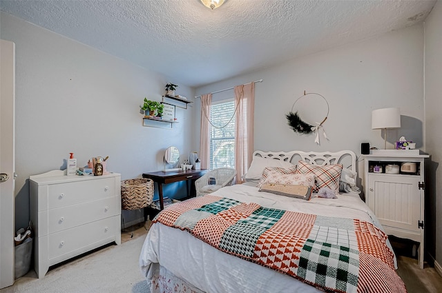 bedroom featuring light carpet and a textured ceiling