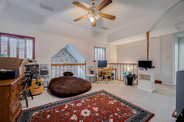 carpeted home office with a textured ceiling, plenty of natural light, and ceiling fan