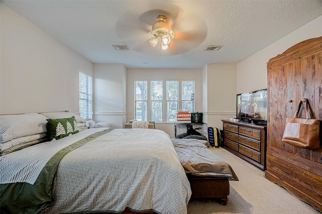 carpeted bedroom with ceiling fan and a textured ceiling