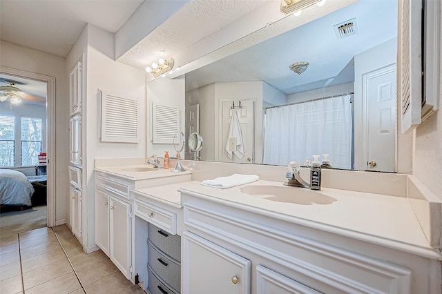 bathroom with tile patterned flooring, vanity, and ceiling fan