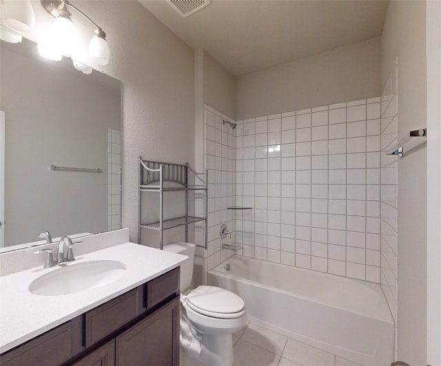 full bathroom featuring tile patterned floors, toilet, tiled shower / bath combo, and vanity