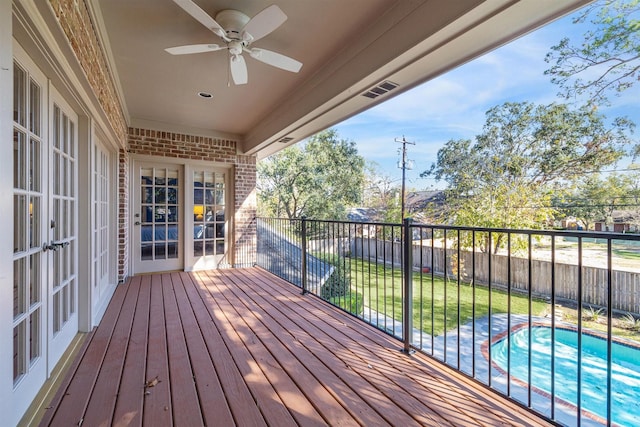 wooden terrace with a fenced in pool, ceiling fan, and a lawn