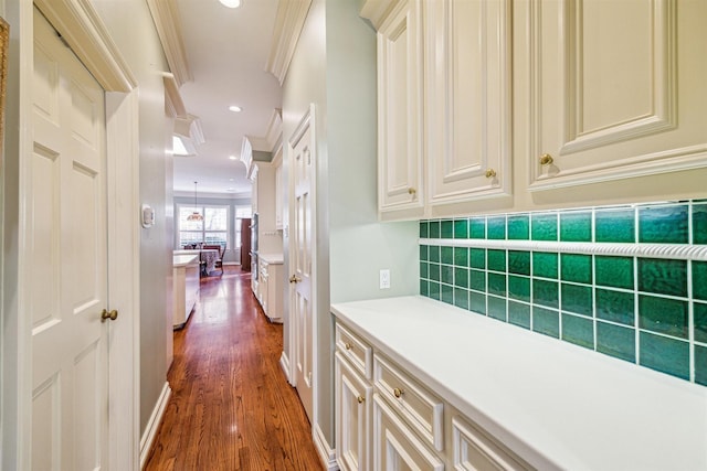 corridor with dark hardwood / wood-style flooring and crown molding