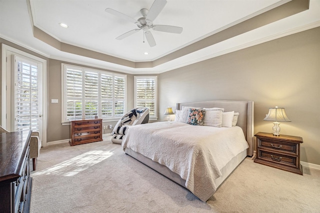 carpeted bedroom with a raised ceiling, ceiling fan, and crown molding