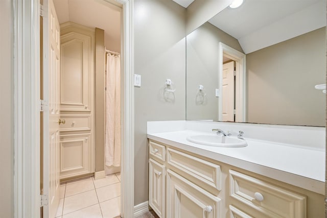 bathroom featuring tile patterned floors, vanity, and lofted ceiling