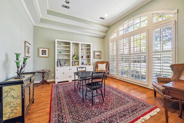 office with ornamental molding, light hardwood / wood-style flooring, and a healthy amount of sunlight