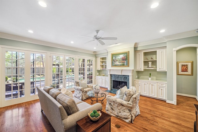 living room featuring a fireplace, light hardwood / wood-style flooring, plenty of natural light, and ceiling fan