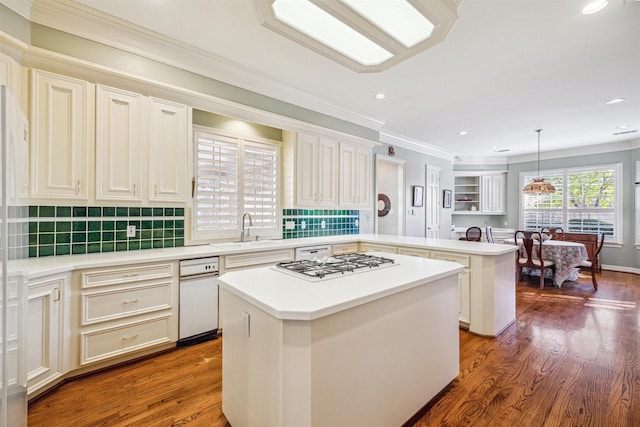 kitchen with a center island, sink, backsplash, kitchen peninsula, and pendant lighting