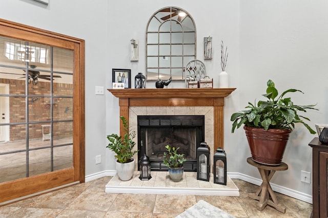 living room featuring ceiling fan and a tile fireplace