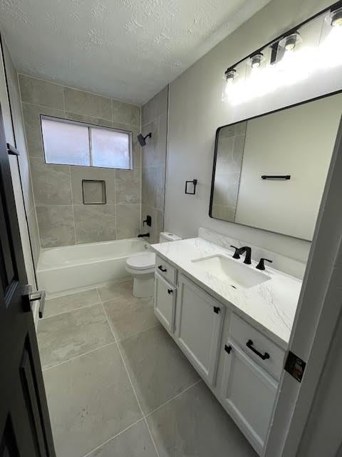 full bathroom with tile patterned flooring, a textured ceiling, toilet, vanity, and tiled shower / bath