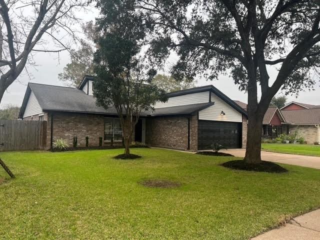 ranch-style house featuring a garage and a front yard