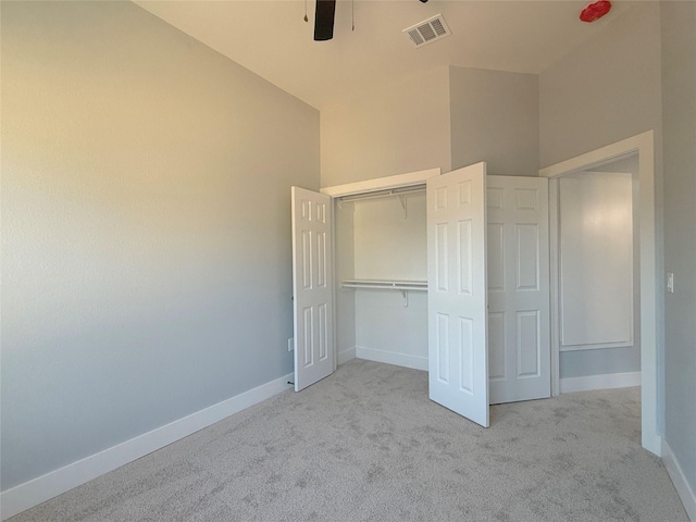 unfurnished bedroom with lofted ceiling, light colored carpet, and a closet