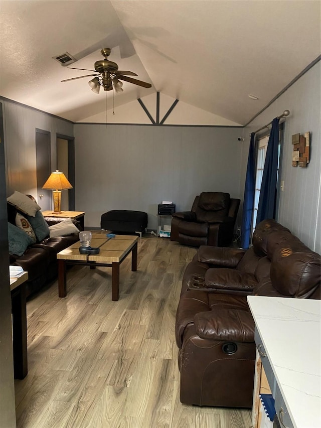 living room featuring ceiling fan, vaulted ceiling, and light wood-type flooring