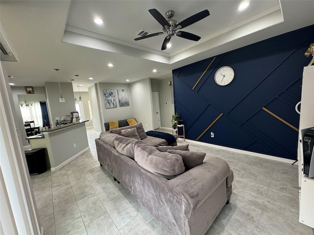 living room with ceiling fan, ornamental molding, and a tray ceiling