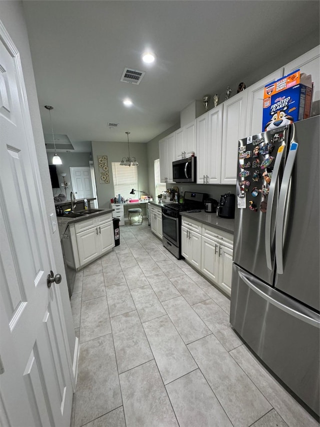 kitchen featuring white cabinets, visible vents, dark countertops, a sink, and stainless steel appliances