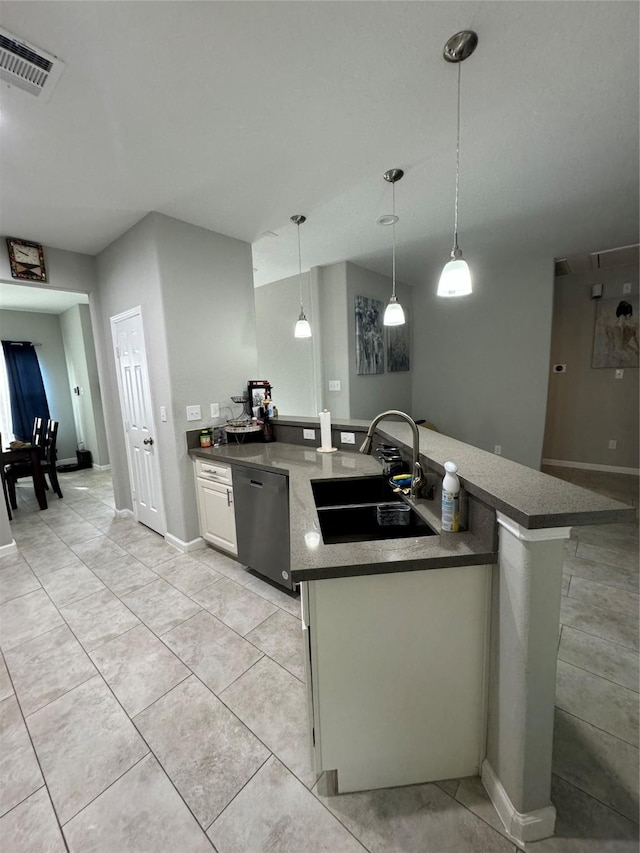 kitchen featuring light tile patterned floors, decorative light fixtures, visible vents, dishwasher, and a sink