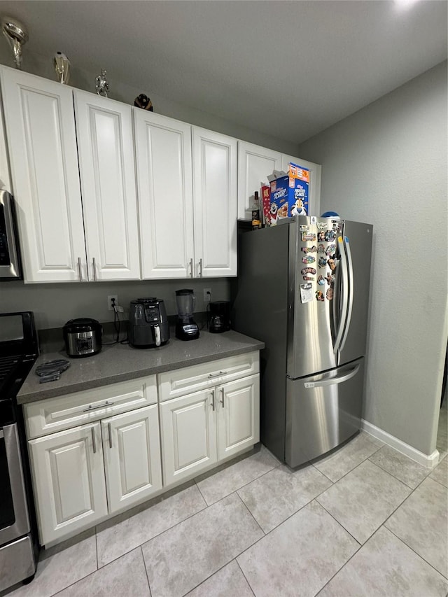 kitchen featuring white cabinets, light tile patterned floors, and stainless steel appliances