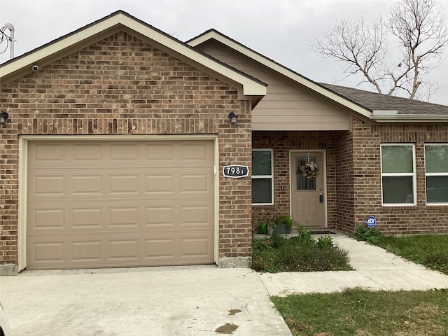 view of front facade featuring an attached garage, concrete driveway, and brick siding