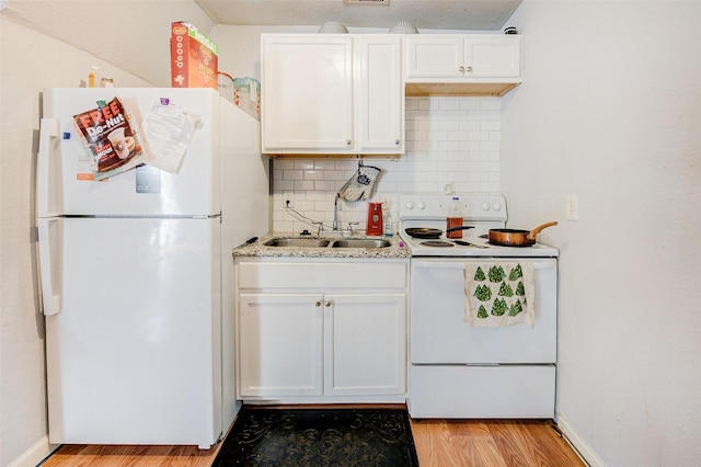 kitchen with white appliances, sink, light hardwood / wood-style flooring, decorative backsplash, and white cabinetry