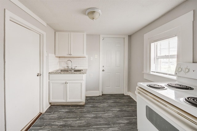 kitchen with electric range, white cabinets, sink, and a textured ceiling