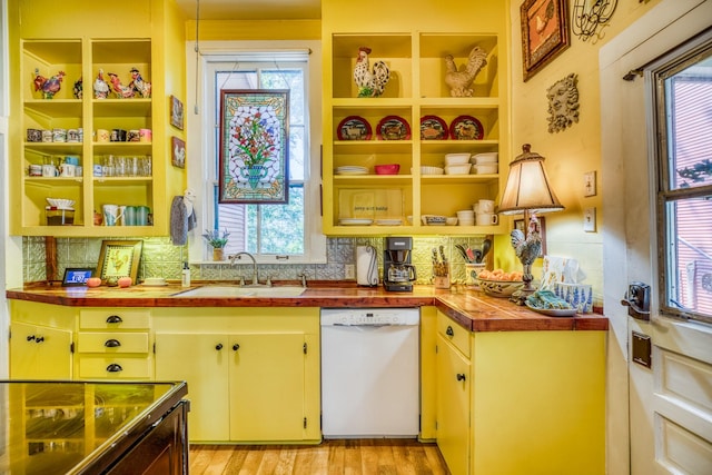 kitchen with sink, light hardwood / wood-style flooring, wooden counters, white dishwasher, and range