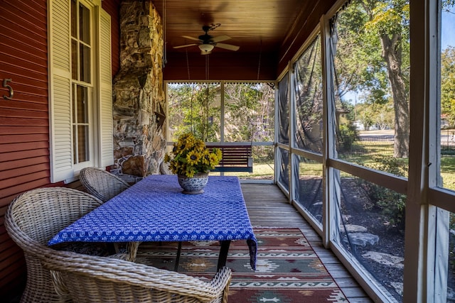 sunroom / solarium with ceiling fan, wooden ceiling, and a wealth of natural light