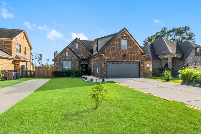 view of front of house with a garage, a front lawn, and cooling unit