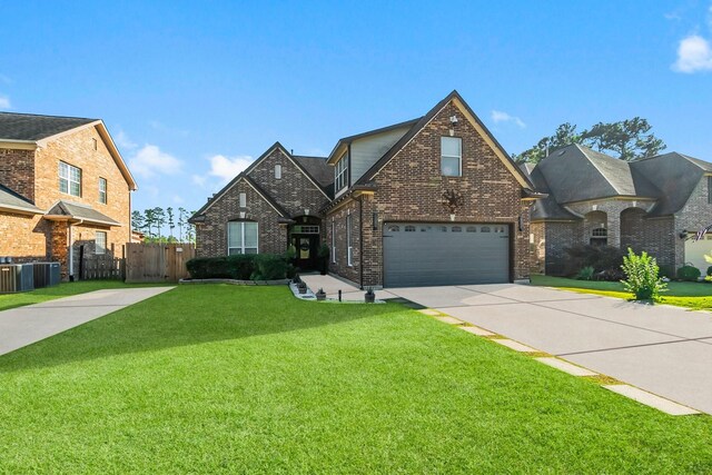 front of property featuring central AC, a garage, and a front lawn