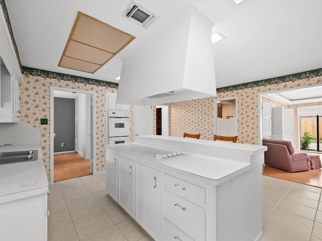 kitchen featuring white cabinetry, sink, light tile patterned floors, and white appliances