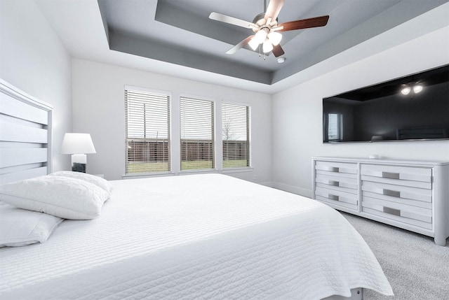 bedroom featuring a tray ceiling, ceiling fan, and carpet floors