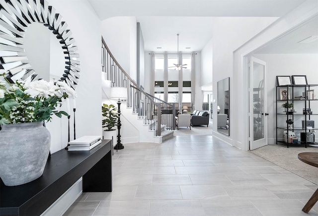 tiled foyer featuring french doors, a towering ceiling, and ceiling fan