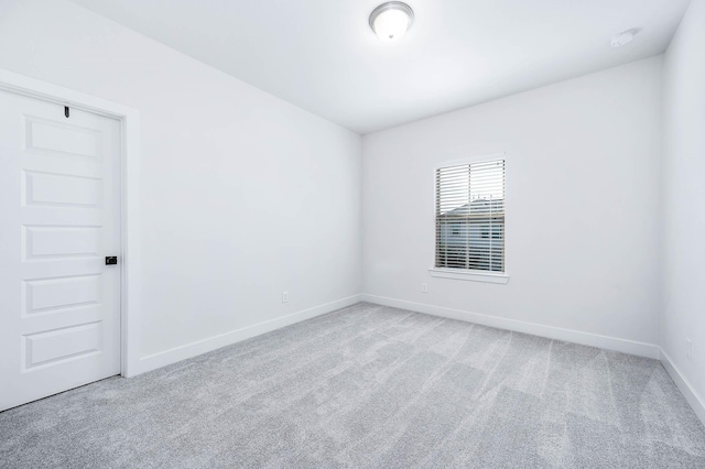 spare room featuring light colored carpet