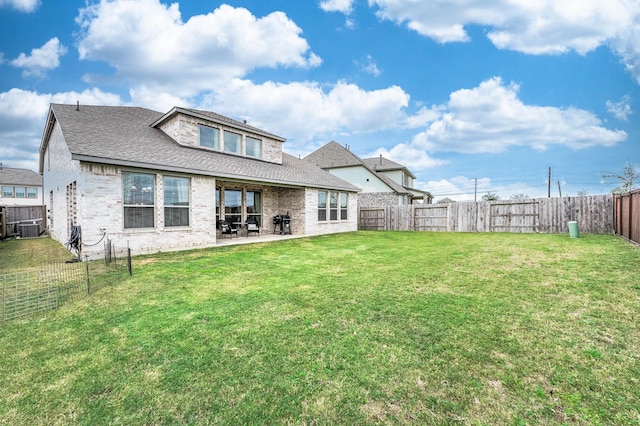 rear view of house with a lawn, a patio, and central AC unit