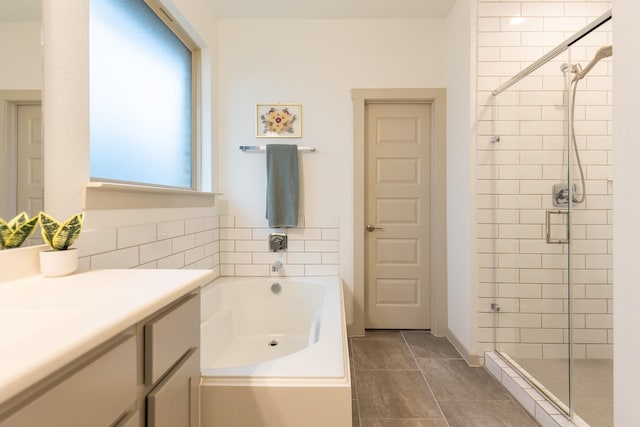 bathroom with plus walk in shower, vanity, and tile patterned flooring