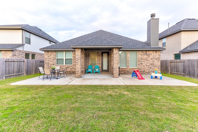 back of property with a yard and a patio