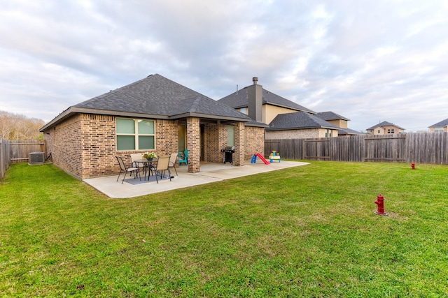 back of property featuring a lawn, a patio area, and central air condition unit